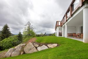 a house with a green lawn next to a building at Chalet Foret - Ferienhaus in Todtnauberg