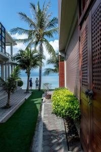a house with a yard with palm trees and the ocean at Neptune's Villa in Haad Rin