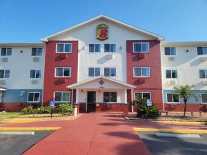 een groot rood-wit gebouw met een bord erop bij Super8 by Wyndham NEARBY Clearwater St Petersburg International Airport in Clearwater