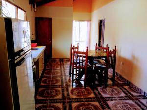 a kitchen with a table and chairs and a refrigerator at Casa Samachiy in Humahuaca