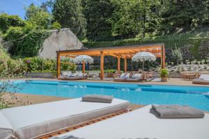 una piscina con sillas y sombrillas junto a una piscina en Diamond Apartments, en Bellagio