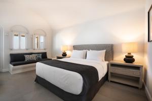 ein Schlafzimmer mit einem großen Bett und einem Sofa in der Unterkunft NĒRO Suites by NOMÉE Hospitality Group in Imerovigli