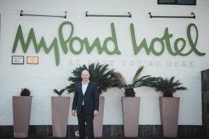Um homem de fato em frente a uma placa em MyPond Stenden Hotel em Port Alfred