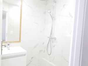 a white bathroom with a shower and a sink at Dupleix Hotel in Paris +5 photos