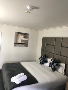 a bedroom with a bed with two towels on it at Gladstone CBD Motel in Gladstone