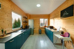 eine Küche mit blauen Schränken und Holzwänden in der Unterkunft Cabana Albă in Beliş