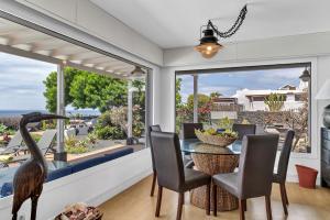 Un pájaro parado junto a una mesa en un comedor. en La Casita, en Playa Blanca