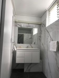 a white bathroom with a sink and a mirror at Gladstone CBD Motel in Gladstone
