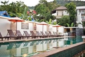 a pool at a hotel with chairs and umbrellas at Neptune's Villa in Haad Rin
