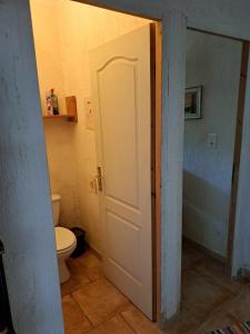 La salle de bains est pourvue de toilettes et d'une porte blanche. dans l'établissement Romantische Bauernhofvilla inmitten der Weinberge, à Salles-d'Aude 39 autres photos