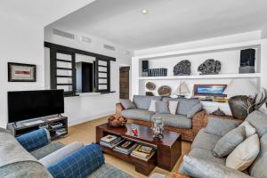 Una sala de estar con dos sofás y un televisor. en La Casita, en Playa Blanca