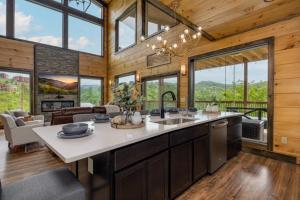 a kitchen with a sink and a living room with windows at Peace Giver by Eden Crest in Gatlinburg