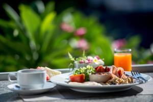 a table with a plate of food and a cup of coffee at Neptune's Villa in Haad Rin