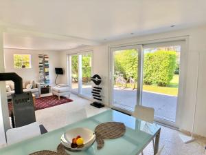 a living room with a glass table and a dining room at Freistehendes Friesenhaus mit Sauna und Garten in Keitum