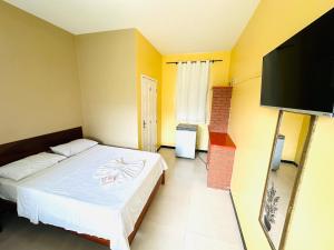 sypialnia z łóżkiem i telewizorem z płaskim ekranem w obiekcie Pousada Acalanto w mieście Aracaju