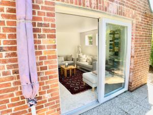 a brick wall with a glass door to a living room at Freistehendes Friesenhaus mit Sauna und Garten in Keitum