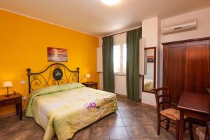 ein Schlafzimmer mit einem Bett und einer gelben Wand in der Unterkunft B&B L'Asfodelo in Villa San Pietro