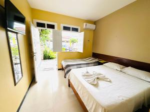 2 letti in una camera con pareti gialle di Pousada Acalanto ad Aracaju