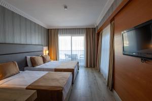 a hotel room with two beds and a flat screen tv at point beach hotel in Marmaris +31 photos