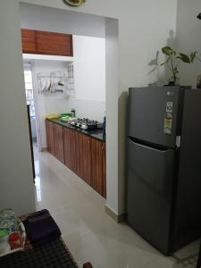 annies inn homestay في كوتشي: مطبخ مع ثلاجة سوداء في الغرفة