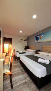 Habitación de hotel con 2 camas y sofá en Hotel Gran Conquistador 33 en Medellín