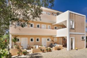 Una vista exterior de un edificio con mesas y sillas. en Helena Inn Kefalonia, en Cefalonia
