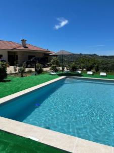 a swimming pool in front of a house at Quinta da Travessa in Cinfães