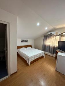 a bedroom with a bed and a flat screen tv at Casa Anda in Mangalia