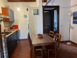 una cucina con tavolo, sedie e tavolo e una cucina con piano cottura di Agriturismo Poggialberi a Castiglione della Pescaia