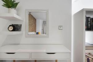 a white bathroom with a mirror and a sink at Manor House Studios By Morethanstays in London