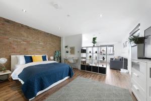 a bedroom with a brick wall and a bed at Manor House Studios By Morethanstays in London +37 photos