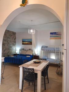 Camera con tavolo, sedie e 2 letti a castello. di Villa Carrieri a Marina di Lizzano