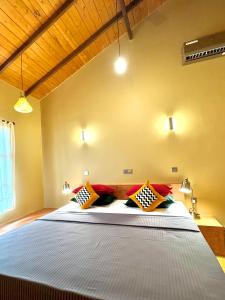 um quarto com uma cama grande e almofadas coloridas em Art Yala em Tissamaharama