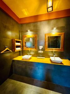 a bathroom with two sinks and two mirrors at Art Yala in Tissamaharama