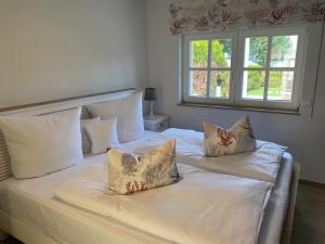 a bedroom with two beds with white sheets and pillows at Fleesensee Resort & Spa in Göhren-Lebbin