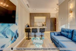 un soggiorno con divano blu e una cucina di Szczecin Apartamenty Aparthotel D'orski a Stettino