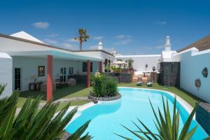 une villa avec une piscine en face d'une maison dans l'établissement Finca del Moral, à Tinajo