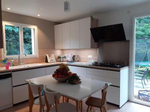 a kitchen with a table with a bowl of fruit on it at Grande maison famille proche de Lyon in Lissieu