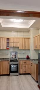 a kitchen with wooden cabinets and a stove at VENUS APARTMENT Kigali in Kigali