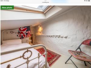 a small attic room with a bed and a flag at The Old Candle Shop in Little Walsingham