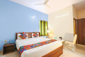 FabHotel Namaha Suites في حيدر أباد: غرفة نوم مع سرير كبير مع بطانية ملونة