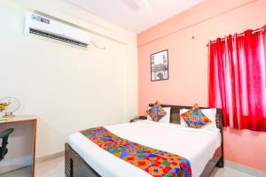 een slaapkamer met een bed en een rood gordijn bij FabHotel Namaha Suites in Hyderabad