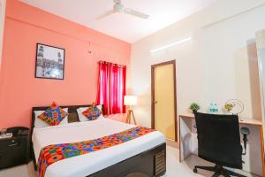 FabHotel Namaha Suites في حيدر أباد: غرفة نوم فيها سرير وتلفزيون