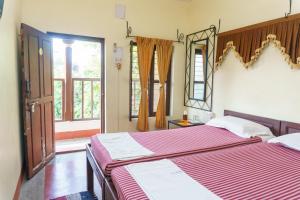 a bedroom with a large bed and a mirror at Kailash Guest House in Puducherry