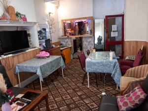 a living room with two tables and a television at My Adam Hotel in Blackpool