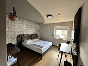 a bedroom with a bed and a table and a desk at Ratshotel - City Aparthotel Aalen in Aalen
