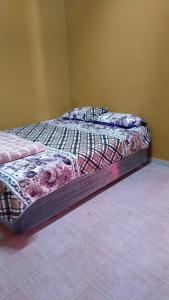 a bed in the corner of a room at Homestay Naimah in Changlun