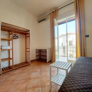 une chambre avec un lit, une table et un balcon dans l'établissement Casa Deborah, à Fontane Bianche