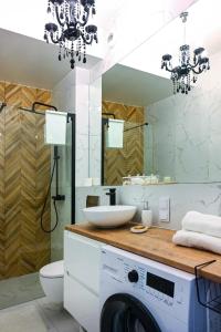 a bathroom with a washing machine and a sink at Apartament Królowej Nilu in Katowice