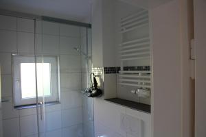 a white bathroom with a shower and a window at Wohnung Julius 5 in Sankt Andreasberg